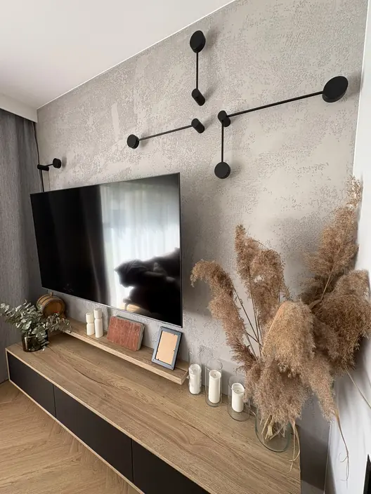 Ściana telewizyjna wykończona betonem dekoracyjnym z wiszącą szafką
